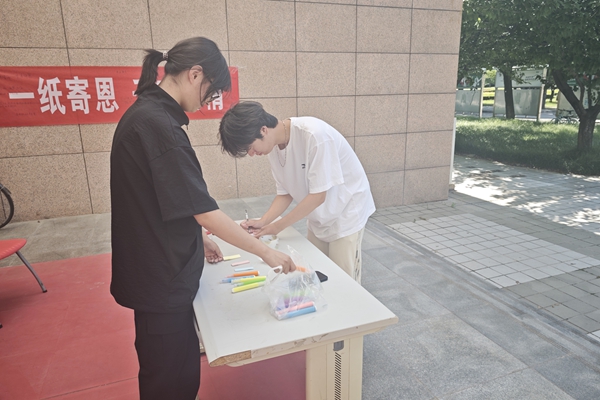 图一 志愿者在布置活动场地_20260615220029.jpg